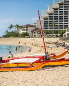 Red and Yellow Catamaran on the beach in front of a hotel in Hawaii 400