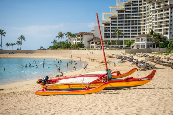 Red and Yellow Catamaran on the beach in front of a hotel in Hawaii 600
