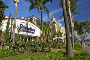 View of the Entrance to the Portofino Inn and Suites in Anaheim through the palm trees 600